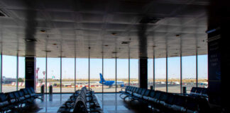 Iranian Drones Torch Kuwait Hub Airport departure lounge with empty seating facing large windows