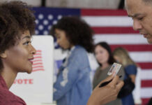Power Play: Ohio Freezes Voting Laws A woman presenting her ID to a man at a voting station