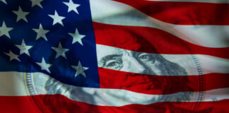 An American flag with a subtle overlay of a hundred-dollar bill