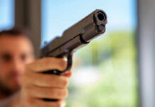 Gun Drama Inside Maui County Hall A close-up of a handgun being pointed by a person in an indoor setting