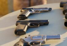 Gun Dealers Caught In State Crackdown Several handguns displayed on a table in sunlight