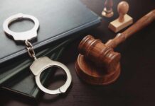 Repeat Killer Finally Gets Life Without Parole Handcuffs and a gavel on a desk with legal books