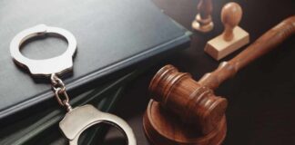 Repeat Killer Finally Gets Life Without Parole Handcuffs and a gavel on a desk with legal books