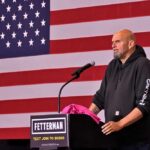 A speaker at a podium in front of an American flag during a political event