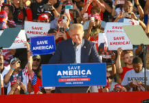 Insiders Kill SAVE Act Before Debate Donald Trump speaking at a political rally with supporters holding signs