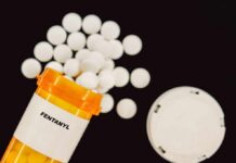 Prescription bottle of fentanyl with white pills scattered around