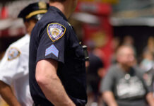 Heavy Security, Multiple Arrests, And Chaos Close-up of a police officers uniform in a busy urban area
