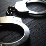 Close-up of metallic handcuffs on a textured surface