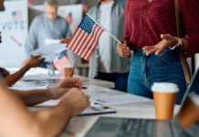 People participating in a voting event with American flags and paperwork