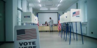 States Cornered: Security Funds On The Line Interior of a polling station with voting booths and officials