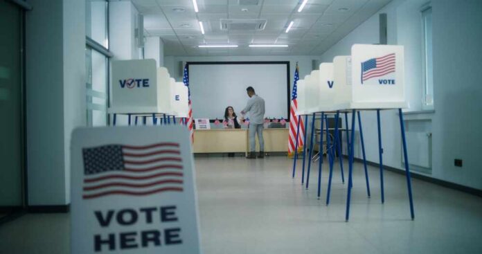 Interior of a polling station with voting booths and officials