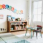 A bright and colorful children's room with a bookshelf and a play table