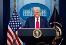 Iran Missiles Fly—Trump Says Hold Fire A political figure at a podium during a press conference in front of the White House