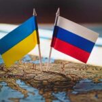 Ukrainian and Russian flags pinned on a map of Eastern Europe