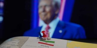 Conflicting Claims Shake Ceasefire Map of Iran with push pins and a blurred figure in the background