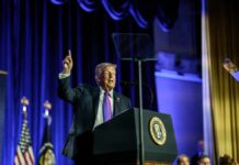 A speaker at a podium gesturing during a political event