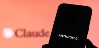 Will Humans—or Algorithms—Decide America’s Next War? A hand holding a smartphone displaying the word 'ANTHROPIC' against a blurred background