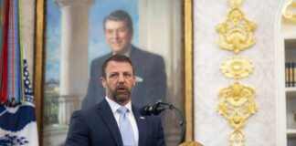 Man in a suit speaks at a presidential podium