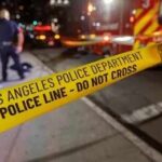 Police tape cordons off a nighttime street scene
