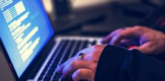 DNC Falls For Costly Email Scam hands typing on a laptop with code on screen