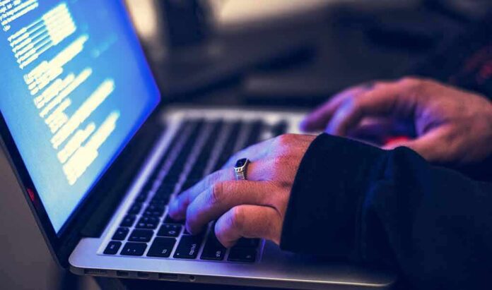 hands typing on a laptop with code on screen
