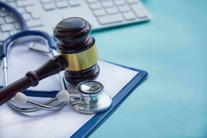 shutterstock_1079150168 Gavel and stethoscope on medical clipboard near keyboard