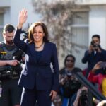 woman in navy suit waving at outdoor event