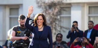 woman in navy suit waving at outdoor event