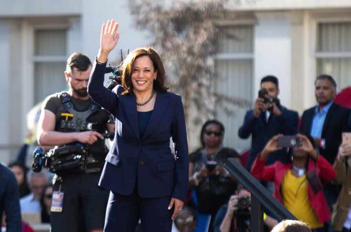 woman in navy suit waving at outdoor event