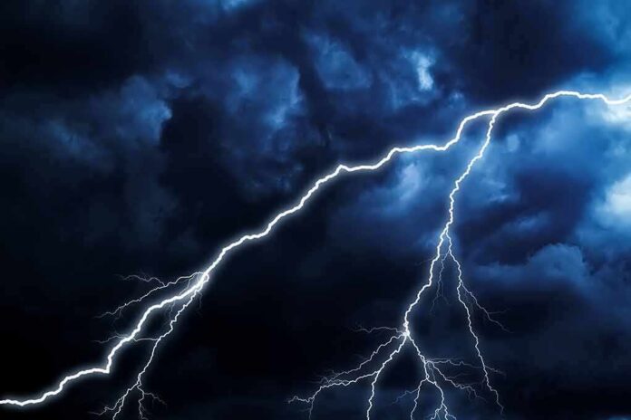 shutterstock_1406842649 Lightning bolts streak across dark storm clouds