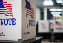 Democrat’s Campaign Hits New Crisis Voting booths with American flags in a polling station