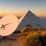 Starlink satellite dish near a pyramid-shaped building at sunset