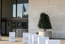 New Plague Case Raises Concerns Entrance of the Hubert H. Humphrey Building with a decorative plant and a flag visible