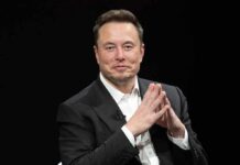 Elon’s Checkbook Rewrites Midterms Man in a dark suit with hands clasped together