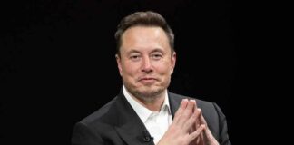 Elon’s Checkbook Rewrites Midterms Man in a dark suit with hands clasped together