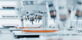 Global Agencies Confirm Marburg Death Automated laboratory equipment with robotic arms dispensing liquids into petri dishes