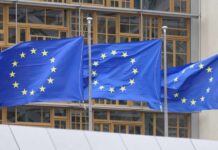 EU Court Broadens Media Sharing Ban Three European Union flags waving in front of a building