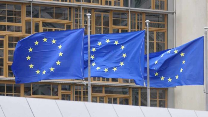 European,Flags,Flying,In,Brussels Three European Union flags waving in front of a building