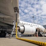 An airplane being fueled at an airport with visible ground support equipment