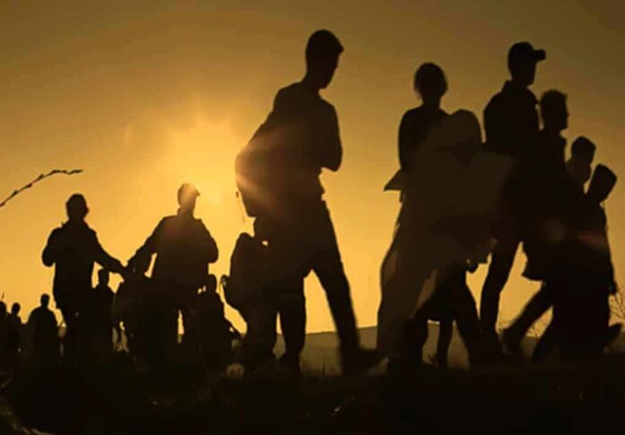 shutterstock_1008288460 Silhouettes of people walking at sunset