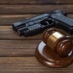 Gavel and handgun on wooden table