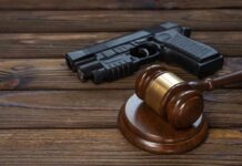 Gavel and handgun on wooden table
