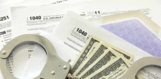 Handcuffs on tax forms with cash