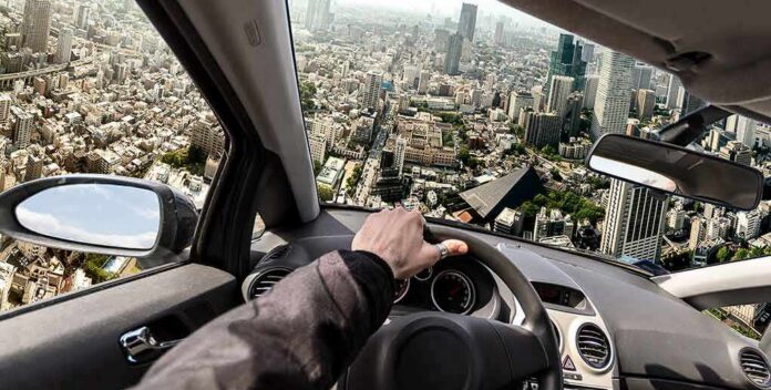 driver's hand on steering wheel over a tilted cityscape