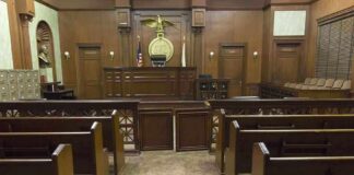 Interior view of an empty courtroom with wooden benches and a judges bench