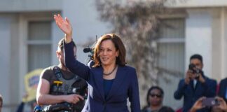 woman in navy suit waving at an outdoor event