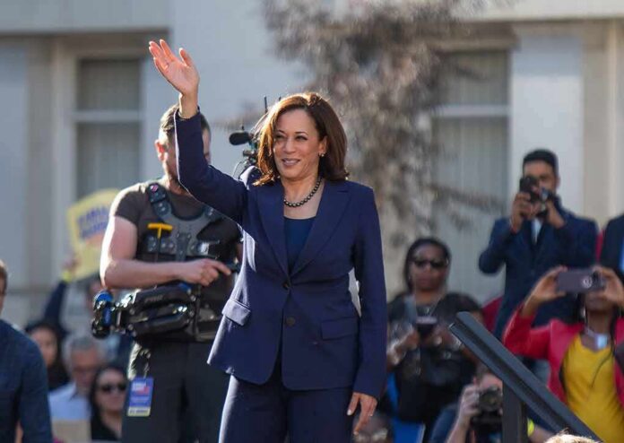 shutterstock_1296858949-1 woman in navy suit waving at an outdoor event
