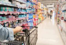 Shopper pushing a cart down a supermarket aisle