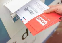 Hand dropping mail-in ballots into a drop box