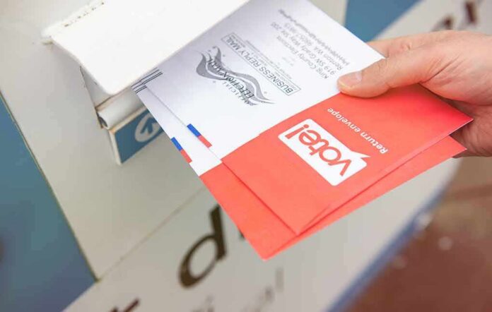 Hand dropping mail-in ballots into a drop box